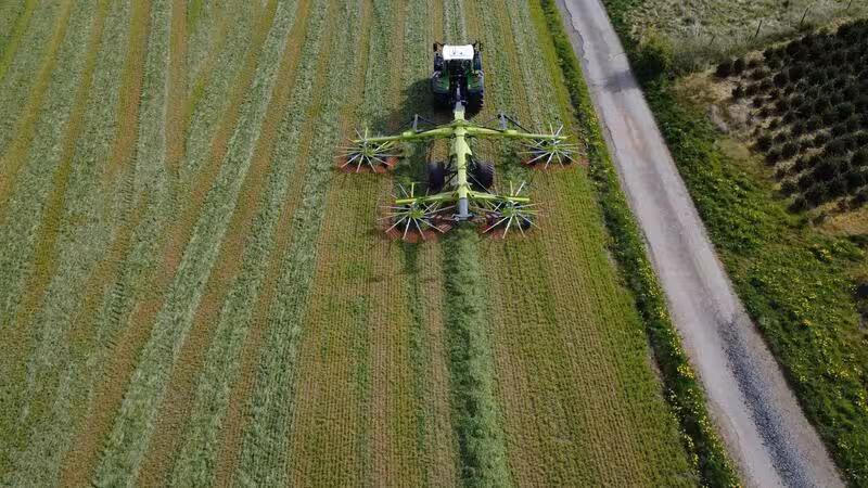 Vue aérienne tracteur Fendt Taserag avec andaineur Claas en prairie