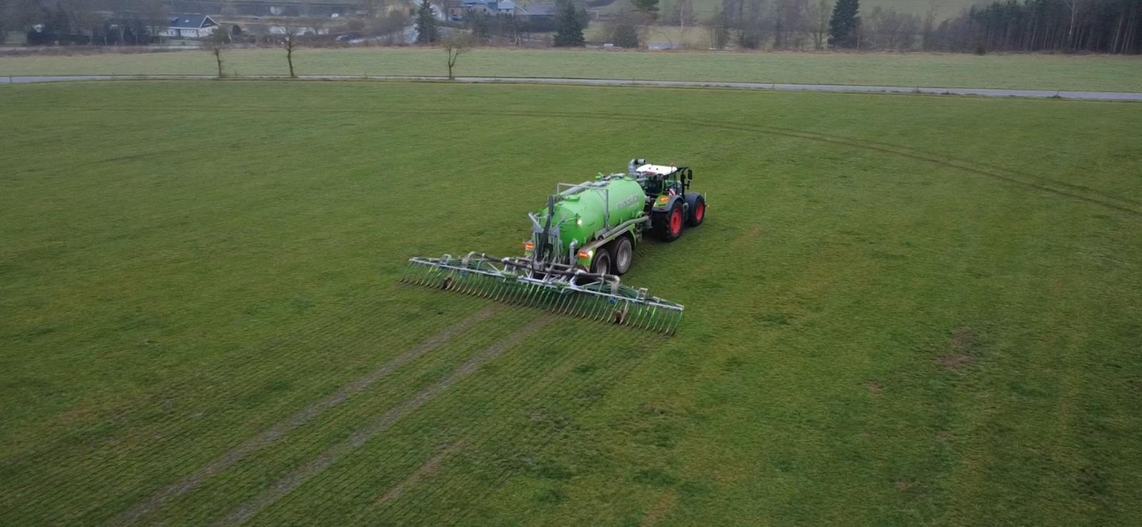 Vue aérienne tracteur Fendt Taserag avec tonne à lisier et rampe pendillards en prairie
